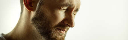 Crying. Caucasian young mans close up cropped shot on studio background, flyer. Concept of human...