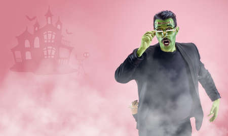 Young man as a zombie on pink background, halloween time, flyer with copyspace. Black friday, cyber monday, sales, autumn concept. Flyer for your ad. Halloween mood, october time, scary and stylish.の写真素材