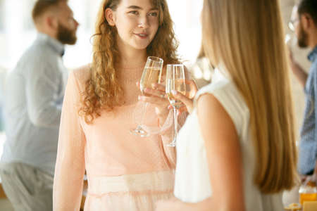 Happiness. People clinking glasses with wine or champagne. Happy cheerful friends celebrate...