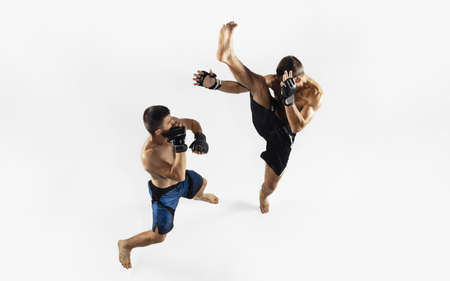 Two professional MMA fighters boxing isolated on white studio background. Top view of couple of muscular athletes. Sport, healthy lifestyle, competition, dynamic and motion, action concept. Copyspace.の写真素材