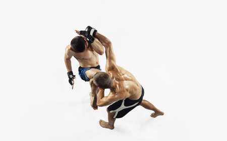 Two professional MMA fighters boxing isolated on white studio background. Top view of couple of muscular athletes. Sport, healthy lifestyle, competition, dynamic and motion, action concept. Copyspace.の写真素材