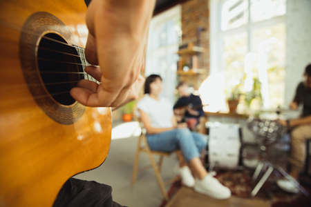 Close up hands playing. Musician band jamming together in art workplace with instruments. Caucasian...