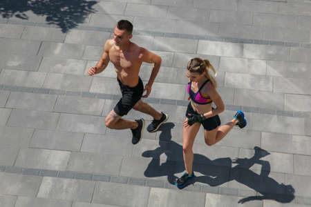 Strong. Young couple in sports outfit doing morning workout outdoors. Man and woman doing cardio and...