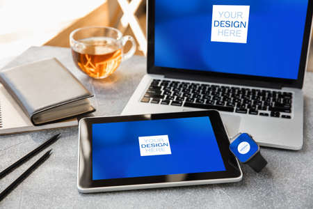 Devices or gadgets with copyspace for ad - mockup, digital concept. Office or co-working location with highly digital workplace with laptop, watch, top view. Online work, shopping, service concept.の写真素材