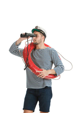 Holding lifeline and binocular. Caucasian male sailor in uniform on white background. Young man using modern devices and gadgets in his work. Concept of tech, professional occupation, job of seaman.の写真素材