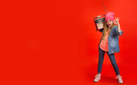 Nice. Caucasian little girls portrait isolated on red studio background. Cute stylish model. Concept of human emotions, facial expression, sales, ad, childhood, education. Copyspace. Flyerの写真素材