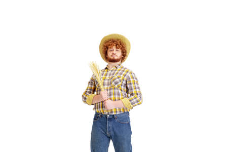 Handsome farmer, rancher isolated over white studio background. Concept of professional occupation, work, job, organic food. Copyspace for ad, text. Caucasian man with equipment for working.の写真素材