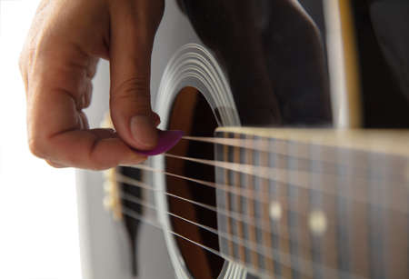 Close up of guitarist hand playing guitar, macro shot. Concept of advertising, hobby, music,...