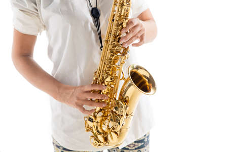 Close up woman playing saxophone isolated on white studio background. Inspired musician, details of art occupation, world classic instrument for jazz and blues. Concept of hobby, creativity.の写真素材