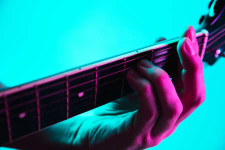 Close up of guitarist hand playing guitar, macro. Concept of advertising, hobby, music, festival,...