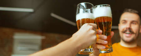 Happy. Hands of friends, colleagues during beer drinking, having fun, clinking bottles, glasses...