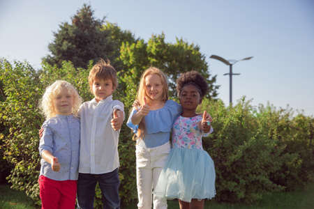 Together. Interracial group of kids, girls and boys playing together at the park in summer day....