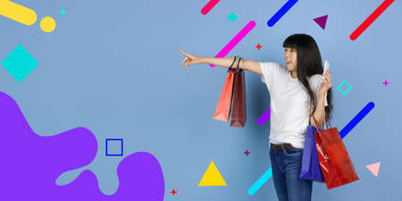 Pointing with shopping bags. Asian womans portrait. Beautiful female model in casual. Concept of...