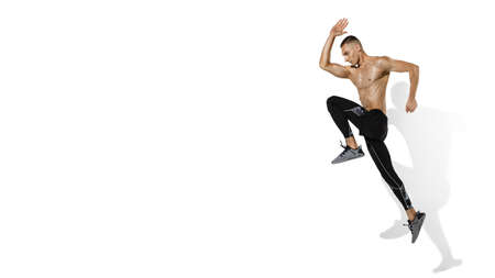 Running, jumping. Stylish young male athlete on white studio background, portrait with shadows....