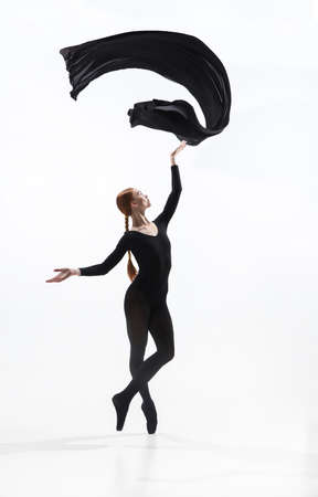 Tender. Young and graceful ballet dancer in minimal black style isolated on white studio background....