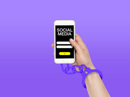 Hand using smartphone, device on top view. Addicted man, wired with chain to social media on the screen with login frame. Technologies, modern, marketing, online. Purple color on background.の写真素材