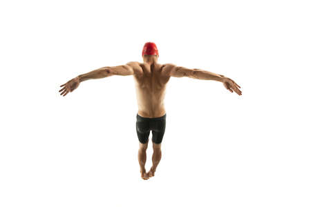 Dynamic. Caucasian professional sportsman, swimmer training isolated on white studio background. Muscular, sportive man practicing in water sport. Concept of action, motion, youth, healthy lifestyle.の写真素材