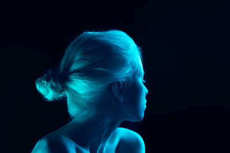 Blue. Close up portrait of beautiful albino girl on dark background in neon light. Blonde female model with dreamlike make-up and well-kept skin. Concept of beauty, cosmetics, style, fashion.の写真素材
