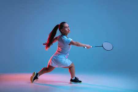 Winner. Beautiful dwarf woman practicing in badminton isolated on blue background in neon light. Lifestyle of inclusive people, diversity and equility. Sport, activity and movement. Copyspace.の写真素材
