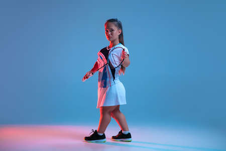 Energy. Beautiful dwarf woman practicing in badminton isolated on blue background in neon light. Lifestyle of inclusive people, diversity and equility. Sport, activity and movement. Copyspace.の写真素材