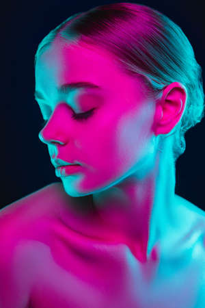 Dreamful. Portrait of female fashion model in neon light on dark studio background. Beautiful caucasian woman with trendy make-up and well-kept skin. Vivid style, beauty concept. Close up. Copyspaceの写真素材