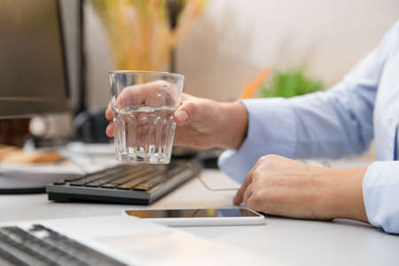 Close up of female hands. Remote working from home. Workplace in home office with PC, devices and...
