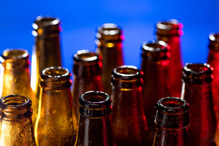 Navy. Neon colored beer bottles, close up isolated on bright studio background. Concept of beer,...