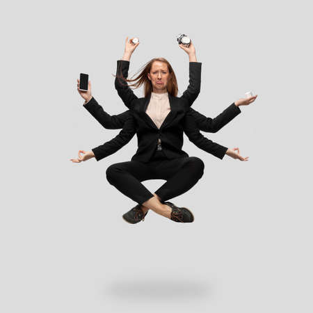 Beautiful business woman, secretary, multi-armed manager levitating isolated on grey studio background. Multi-task worker like Shiva. Concept of business, deadline, balance, time management.の写真素材
