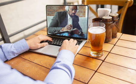 Remote working, online entertainment during quarantine. Man watching stream in bar, restaurant with...