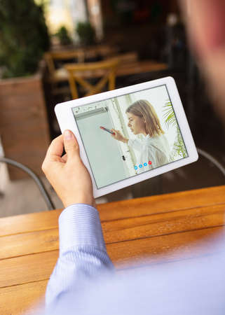Remote working, online entertainment during quarantine. Man watching stream in bar, restaurant with PC, devices and gadgets. Concept of distance learning, isolation, business, shopping, conference.の写真素材