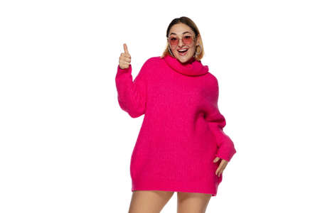 Eyewear. Beautiful young woman bright pink comfortable sweater, long sleeve isolated on white studio...