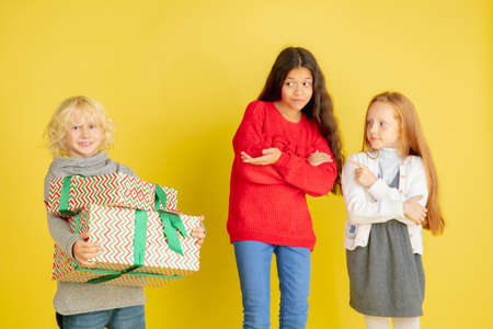 Giving and getting presents on Christmas holidays. Group of happy smiling children having fun,...