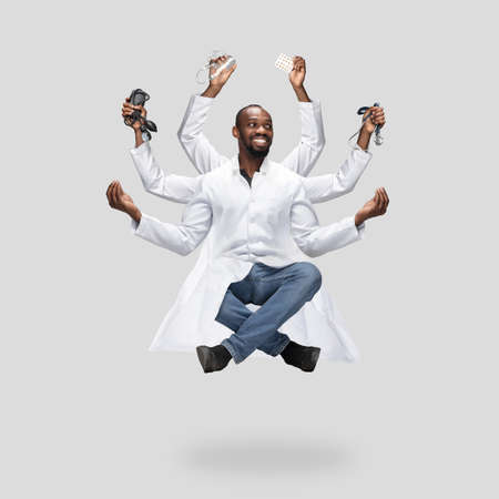 Handsome african doctor, multi-armed man levitating isolated on grey studio background with...