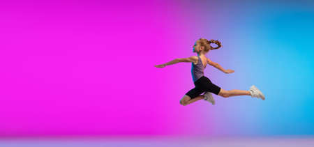 Flyer. Teenage girl, professional runner, jogger in action, motion isolated on gradient pink-blue background in neon light. Concept of sport, movement, energy and dynamic, healthy lifestyle.の写真素材