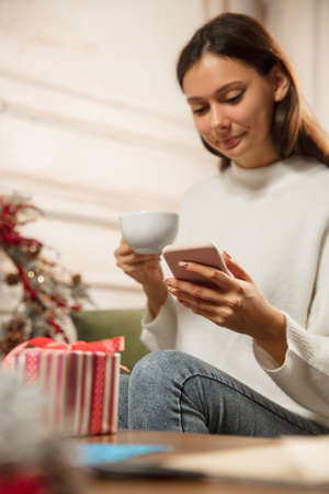 Woman writing message, greetings for New Year and Christmas 2021 for friends or family with her...