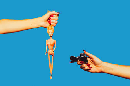Hands with doll and white lighter. Modern art collage in pop-art style. Hands isolated on trendy colored background with copyspace, contrast. Modern design with copyspace for advertising. Trendy colors.の写真素材