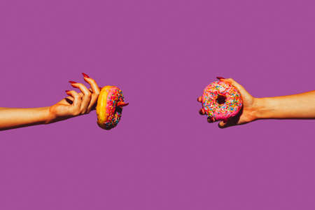 Donuts. Modern art collage in pop-art style. Hands isolated on trendy colored background with copyspace, contrast. Modern design with copyspace for advertising. Trendy colors.の写真素材