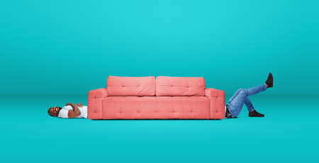 Tall high man and long sofa isolated on blue studio background. Unusual delighted and long. Copyspace for offer, advertising, artwork, inspiration and hobby, mood concept. Humor, weird collage.の写真素材
