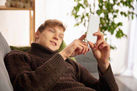 Man reading message, greetings for New Year and Christmas 2021 from friends or family with his...