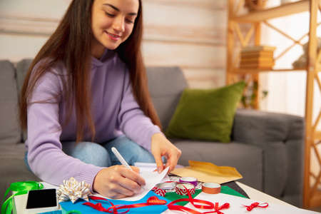 Comfortable. Woman writing letter, greeting card for New Year and Christmas 2021 for friends or...