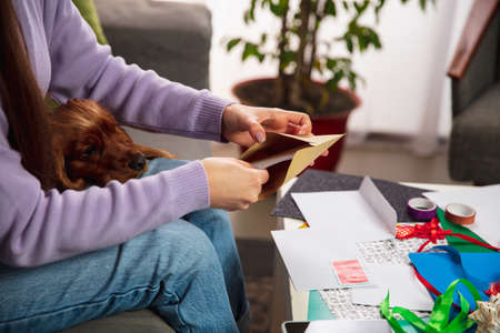 Comfortable. Close up female hands opening, recieving greeting card for New Year and Christmas 2021...