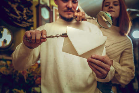 Waxed envelope. Smiling family, couple looking for home decoration and holidays gifts in household store. Stylish and retro things for greetings or design. Interior renovation, celebrating time.の写真素材