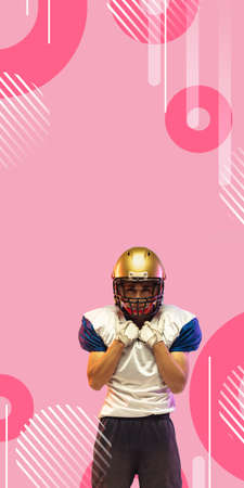 American football player in helmet isolated on pink geometric styled studio background, vertical flyer with copyspace for ad, social media, offers. Concept of sport, movement, achievements, action.の写真素材