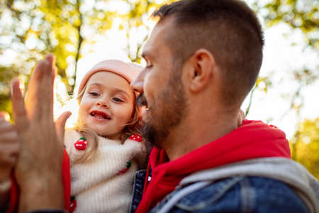 Hugs. Happy father and little cute daughter walking down the forest path in autumn sunny day. Family...