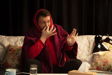 Scared. Man wrapped in a plaid trying to protect himself from somebodys sick near by, looks...