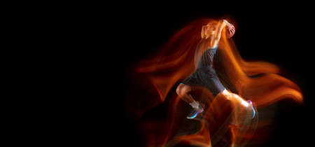 Flyer with copyspace. Young east asian basketball player in action and motion jumping in mixed light...
