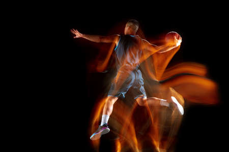 Mad playing Young east asian basketball player in action and motion jumping in mixed light over dark studio background. Concept of sport, movement, energy and dynamic, healthy lifestyle.の写真素材