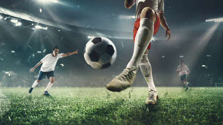 Exciting moment. Young male soccer or football players attacking at the stadium in flashlights, spotlights. Concept of professional sport, competition, team play, hobby, motion, movement. 3D render.の写真素材