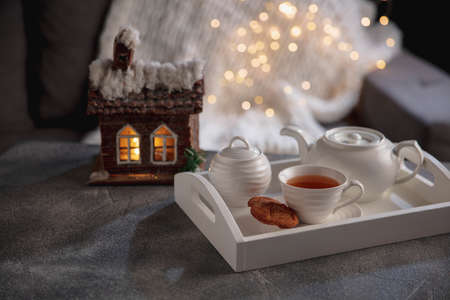 English tea and cakes on wooden grey table, closeup. White wooden tray with tea set. The concept of home atmosphere and comfort, romantic date, winter, home comfort, indoors, Christmas or New Year.の写真素材