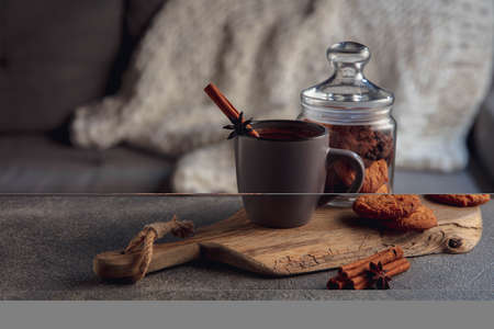 Cup of tea or coffee with cinnamon and cookies isolated on grey and white background. The concept of...